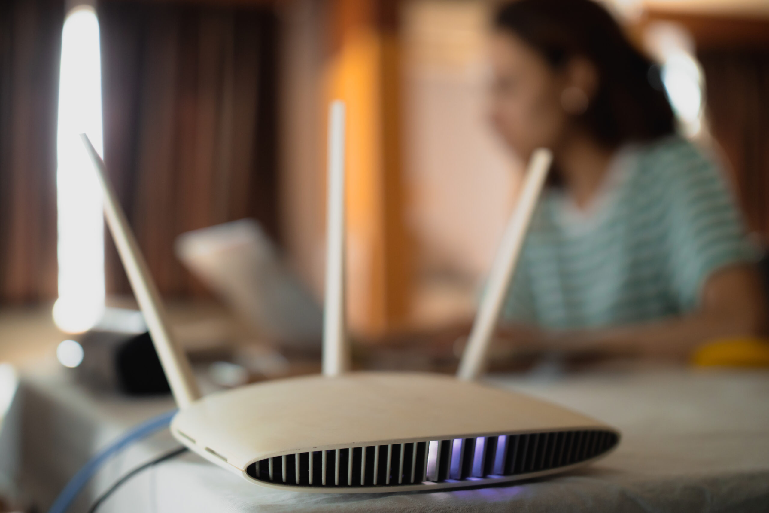 A woman is working at home using a modem router, connecting the